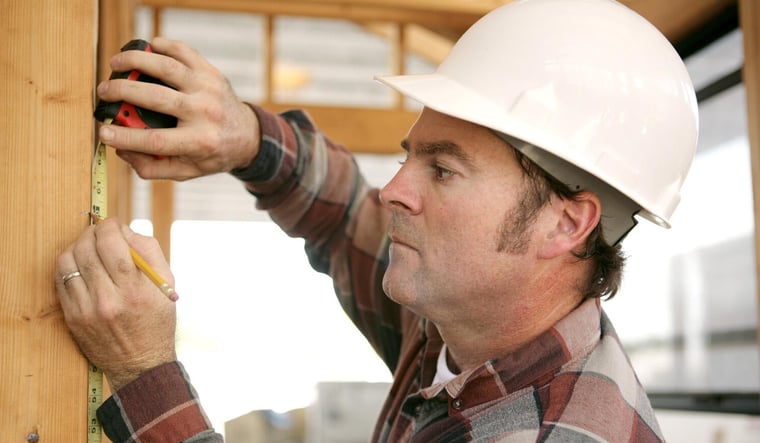 Residential construction worker taking measurements